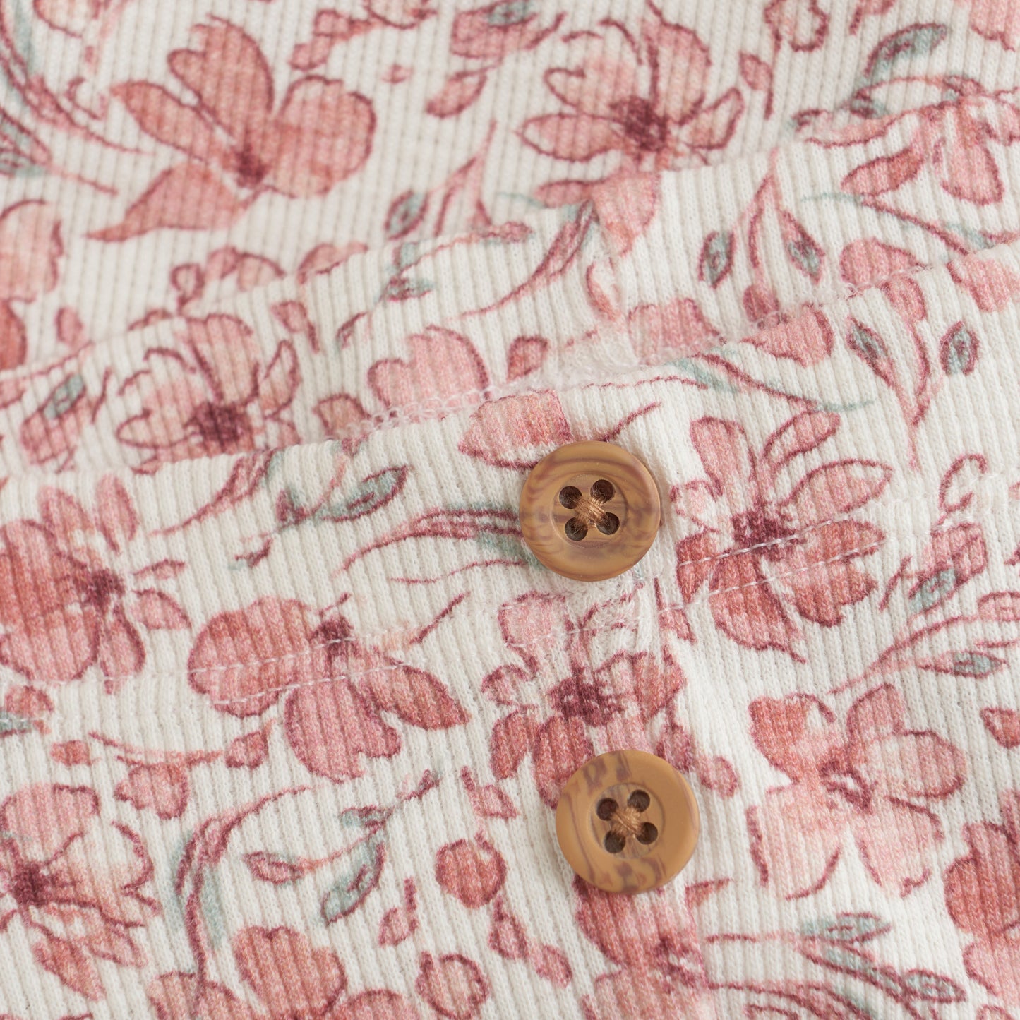 Close up product image of ivory baby leggings with a bright floral print
