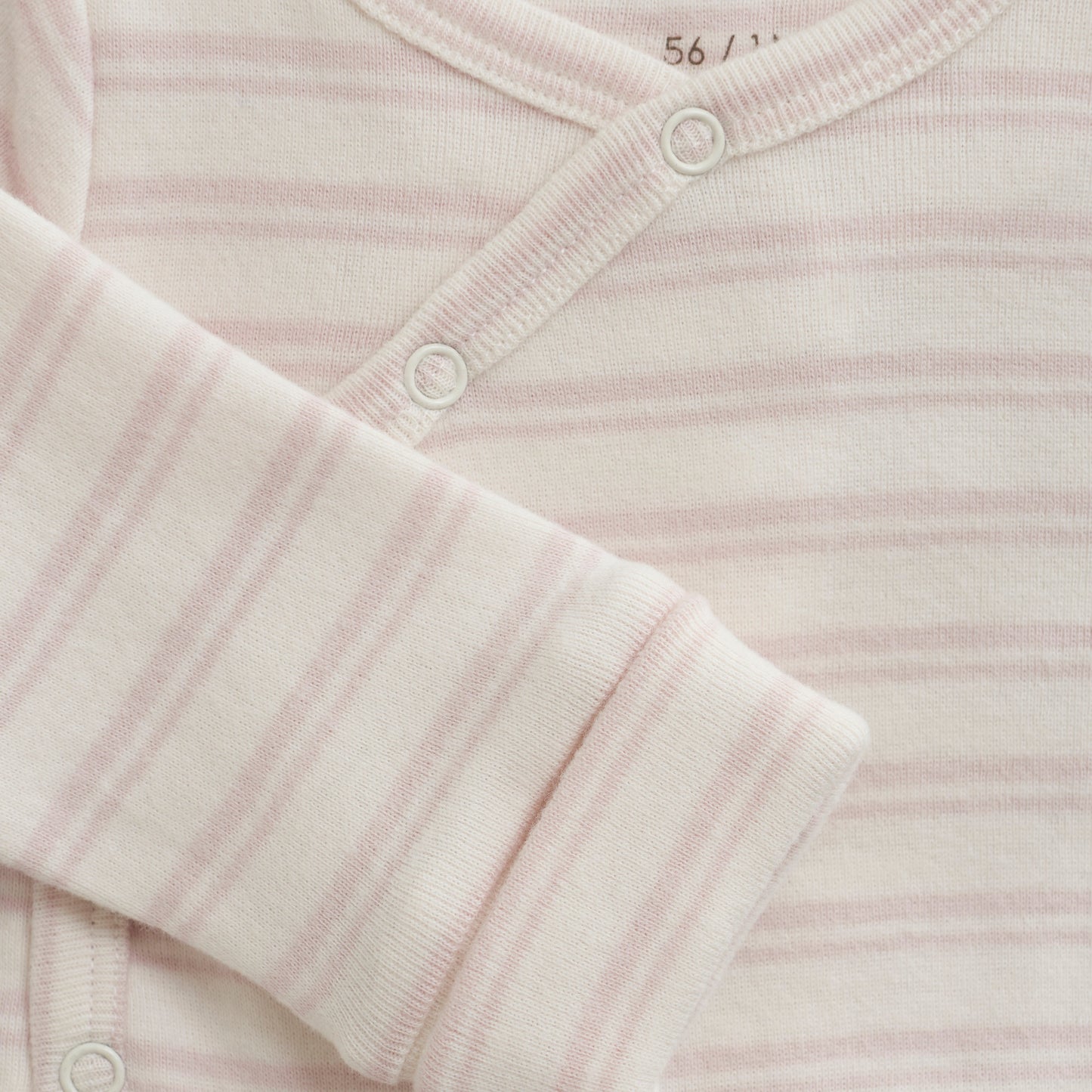 Close up product image of a long sleeve wrap front baby bodysuit