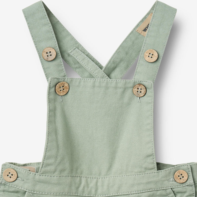 Close up product image of teal baby overalls