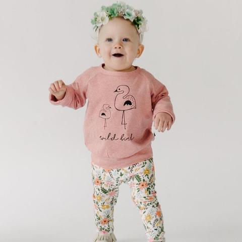 toddler standing in a pair of floral leggings and a sweatshirt