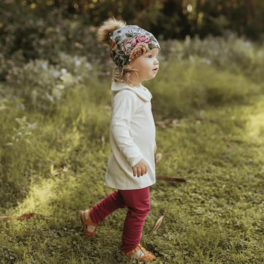 toddler walking outside in a pair of pomegranate leggings and sweatshirt