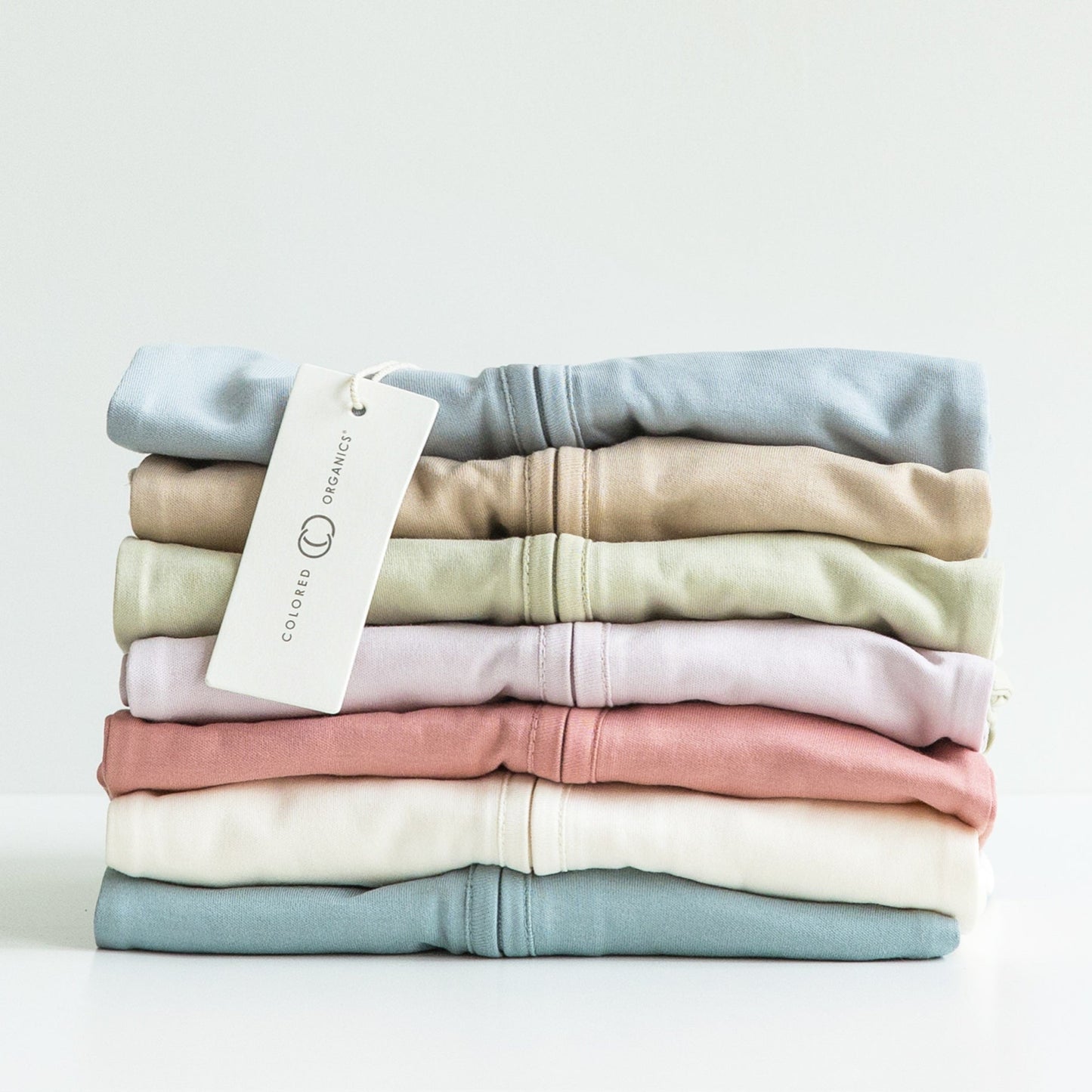 Neatly folded pile of baby sleepers in different colours