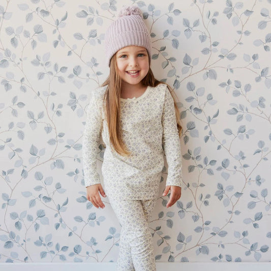 young girl standing in a matching floral shirt and leggings