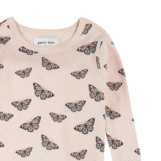 close up pattern detail of a monarch butterfly print on a light pink background