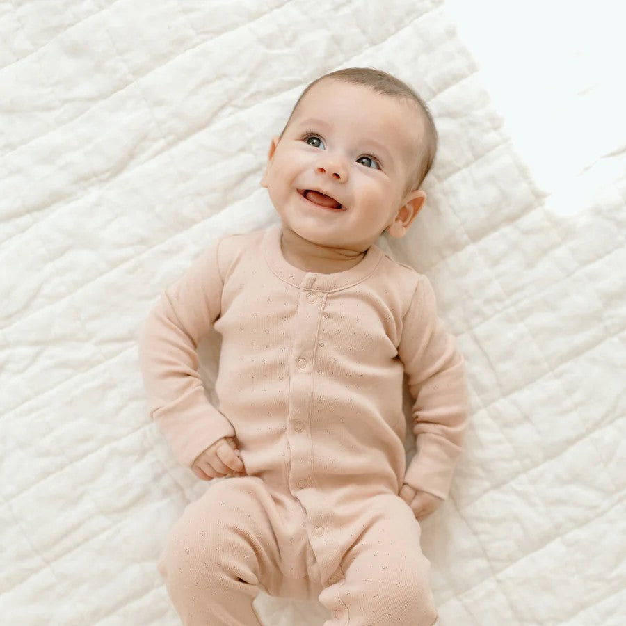 baby laying in a cotton footed sleeper