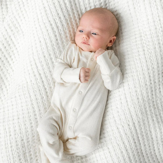 baby laying in a cotton footed sleeper