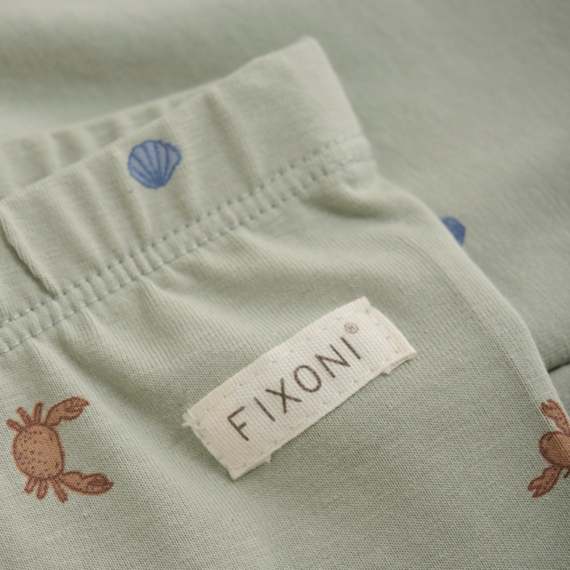 Close up product image of baby leggings in a green desert print