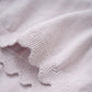 Close up product image of a knit baby dress in light lilac