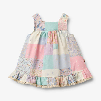 Flat front product image of patchwork baby dress with ruffles