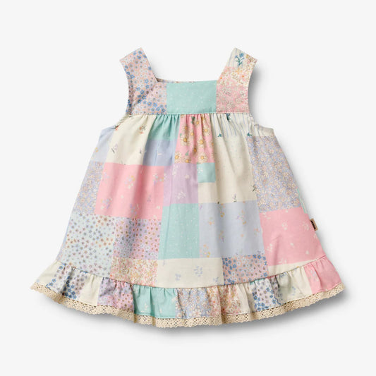 Flat front product image of patchwork baby dress with ruffles