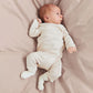 Lifestyle product image of a child holding a rainbow sweater across her back