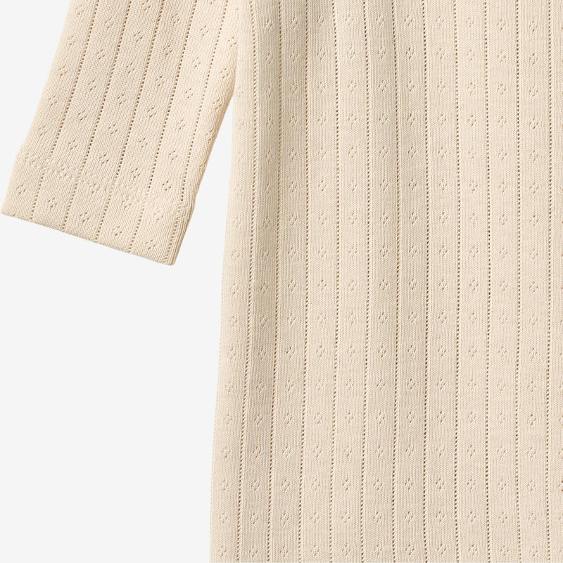 Close up product image of pale peach baby wrap romper