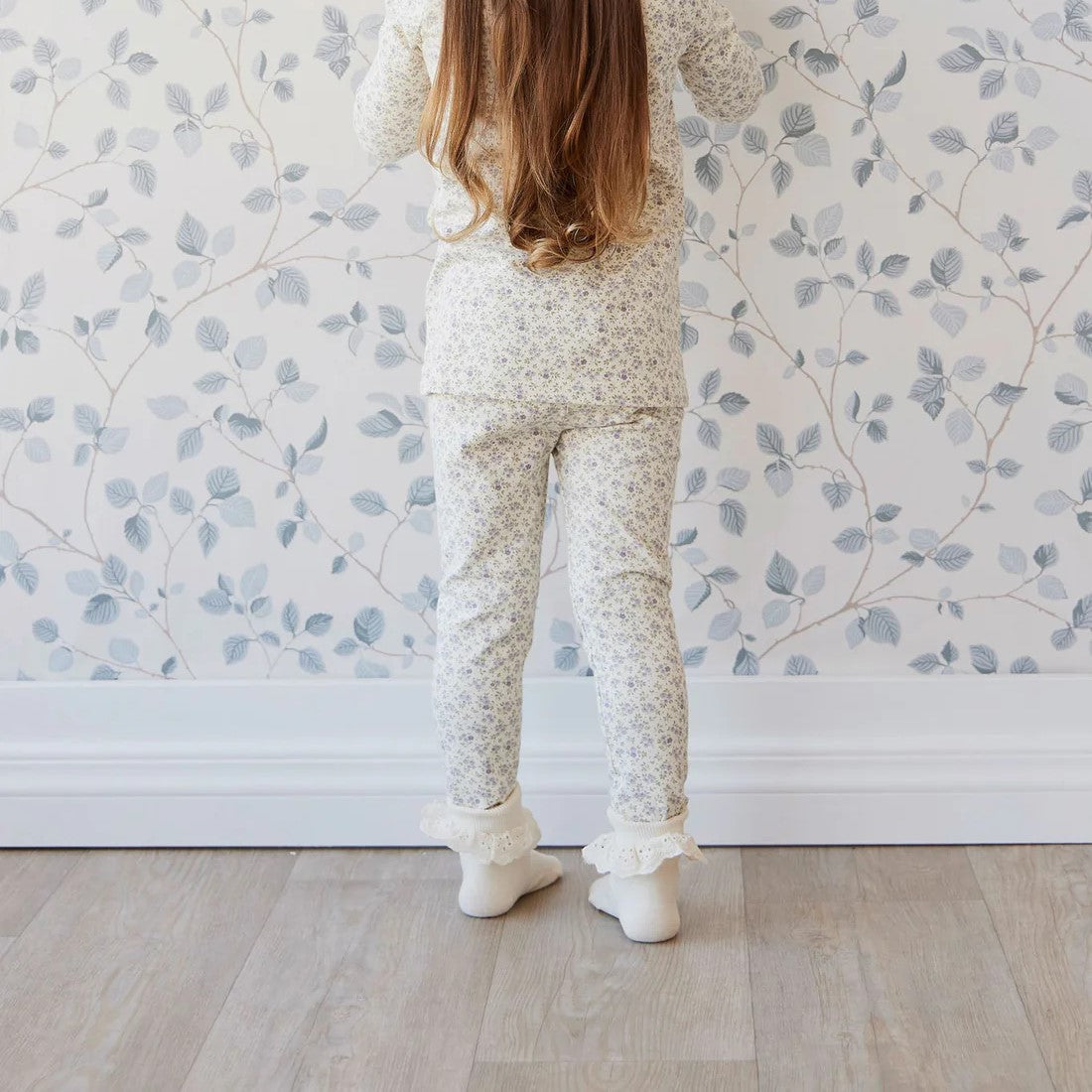 young girl standing in a matching floral shirt and leggings