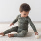 small toddler sitting in a two-piece dark green pyjama set
