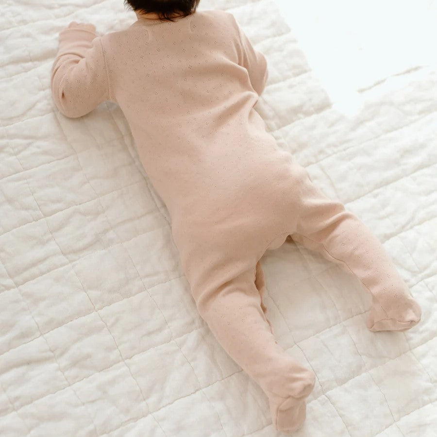 baby laying in a cotton footed sleeper