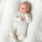 baby laying in a cotton footed sleeper