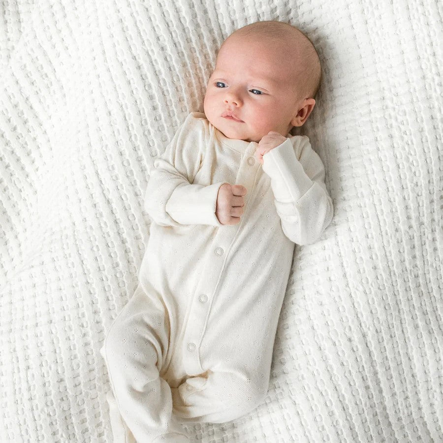 baby laying in a cotton footed sleeper